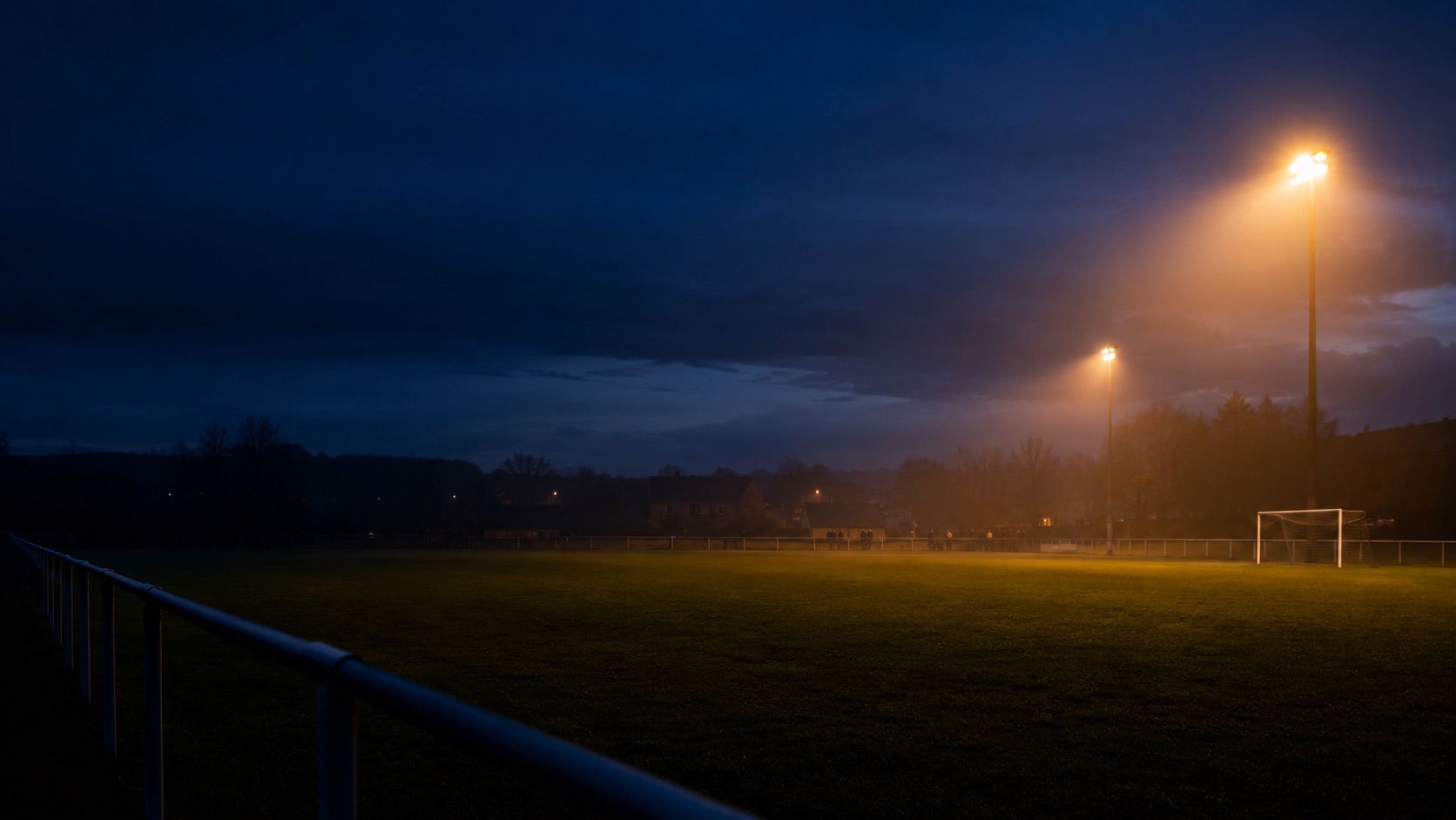 Un terrain de football amateur sous les projecteurs, à l’heure bleue (illustration)